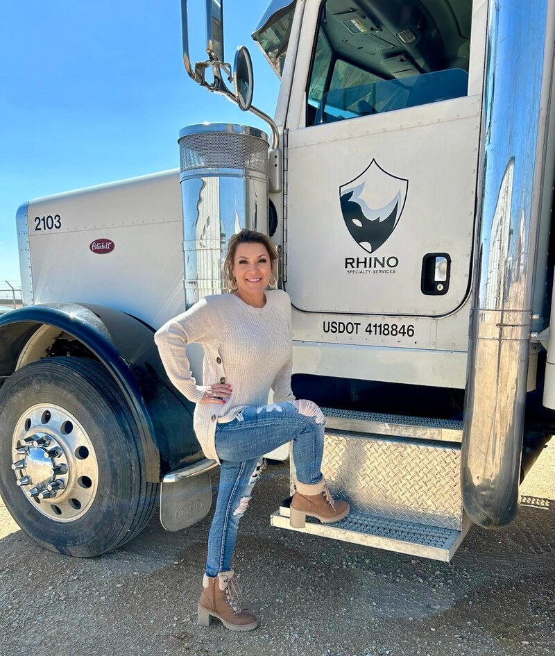 Katrina Smith, co-owner of Rhino Specialty Services, beside her Rhino-branded Peterbilt 2103