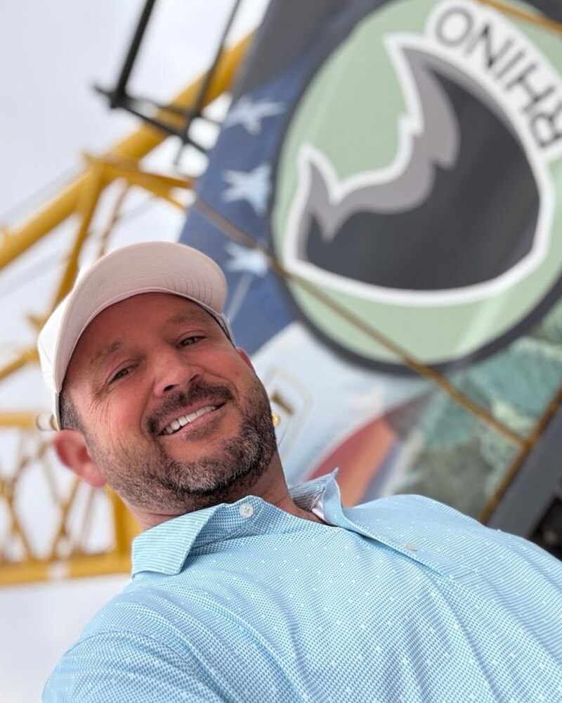 Pete Smith, co-owner of Rhino Specialty Services, on a jobsite in front of a Rhino-branded crane