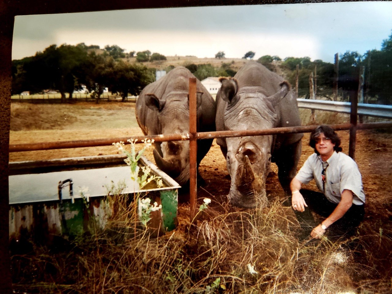 Pete's dad at his Kerrville, TX exotic animal ranch with two rhinos