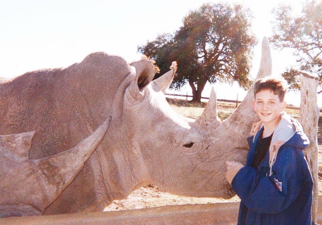A young Pete Smith at his family's Kerrville ranch with a full-grown rhino
